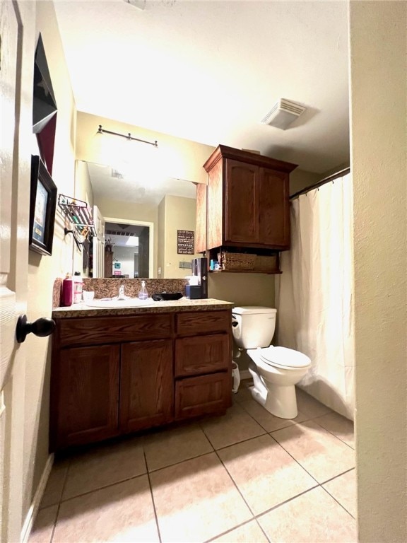 bathroom featuring tile patterned flooring, vanity, and toilet