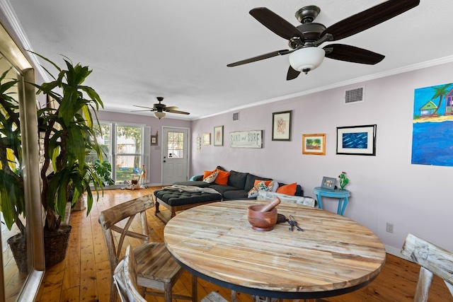 dining area with wood-type flooring, ceiling fan, and crown molding