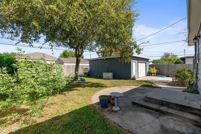 view of yard featuring a garage, an outdoor structure, and a patio area