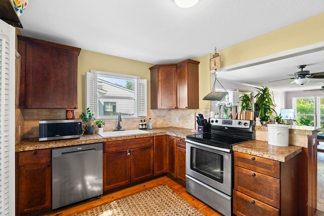 kitchen featuring kitchen peninsula, plenty of natural light, sink, and appliances with stainless steel finishes