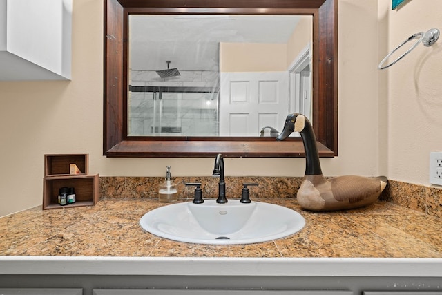 bathroom with walk in shower and vanity