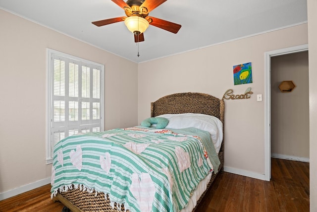 bedroom featuring ceiling fan, crown molding, and dark hardwood / wood-style flooring