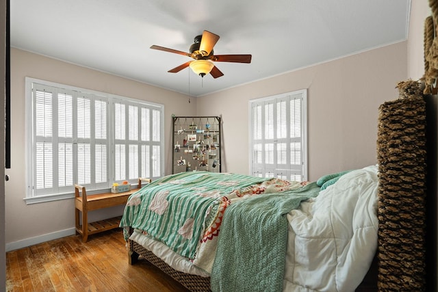 bedroom featuring ornamental molding, wood-type flooring, ceiling fan, and a closet