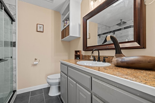 bathroom with vanity, tile patterned floors, toilet, and an enclosed shower