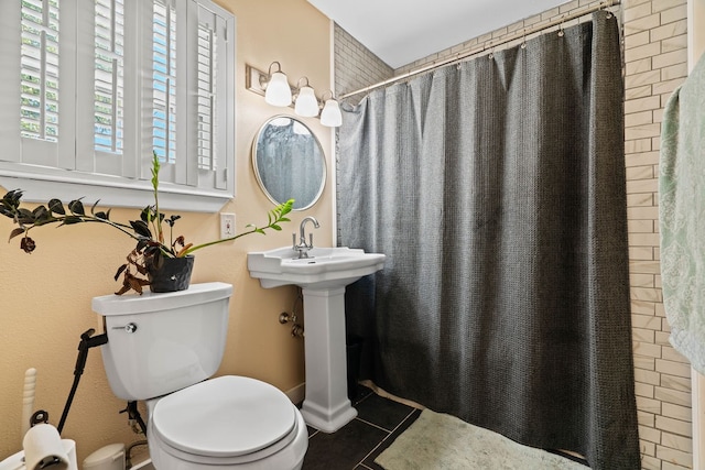 bathroom featuring tile patterned flooring, toilet, and a shower with curtain