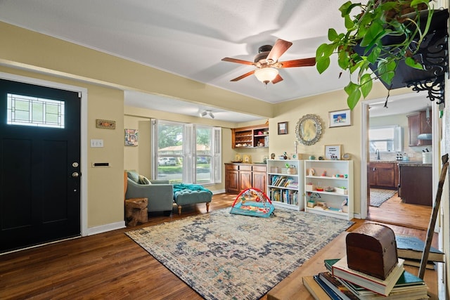 game room with dark wood-type flooring and ceiling fan