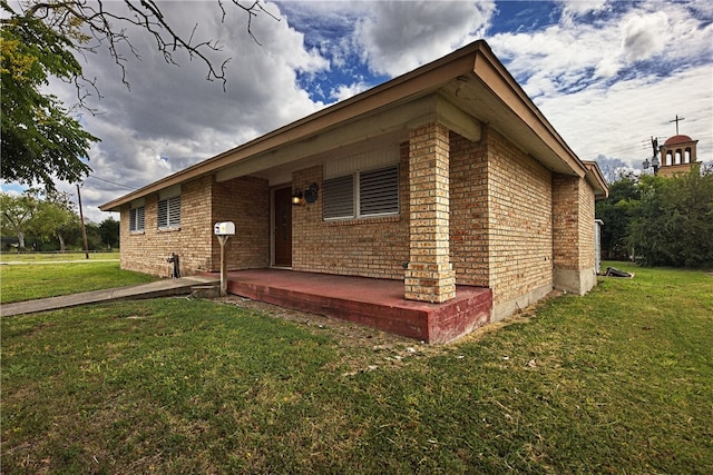 view of side of property featuring a lawn and a patio