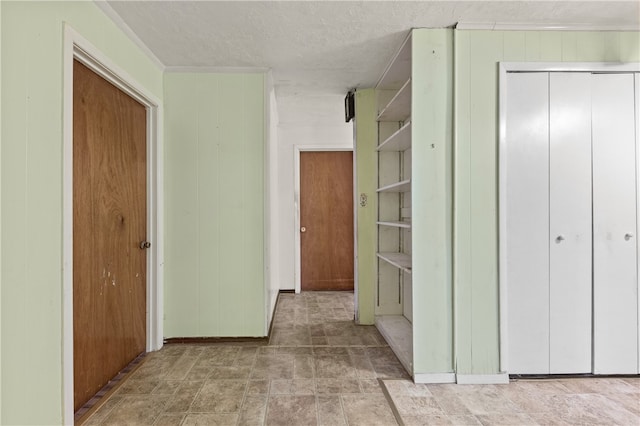 hall featuring wood walls and a textured ceiling