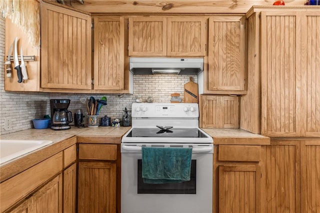 424 Trojan St, Port Aransas, TX 78373 - kitchen with electric range, under cabinet range hood, tasteful backsplash, and tile countertops