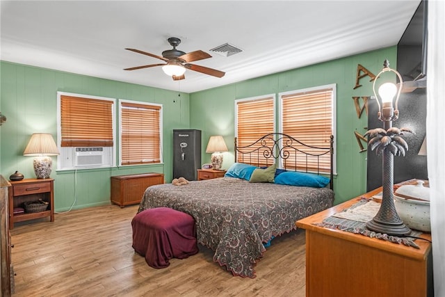 424 Trojan St, Port Aransas, TX 78373 - bedroom featuring wood finished floors, cooling unit, a ceiling fan, and a decorative wall
