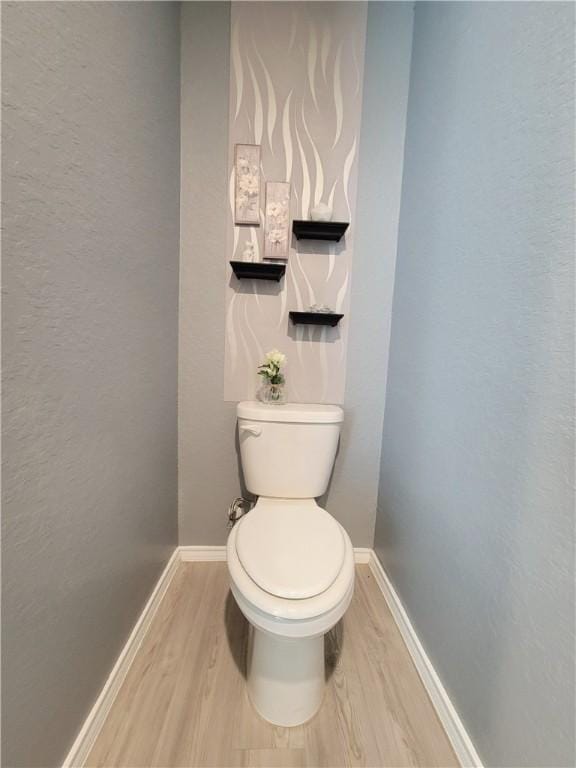 bathroom with toilet and wood-type flooring