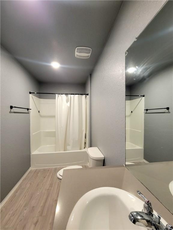 full bathroom with sink, toilet, shower / tub combo, and hardwood / wood-style flooring