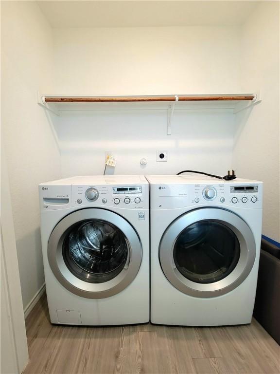 clothes washing area featuring separate washer and dryer and light wood-type flooring