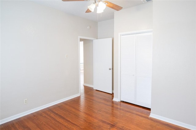 unfurnished bedroom featuring baseboards, visible vents, ceiling fan, wood finished floors, and a closet