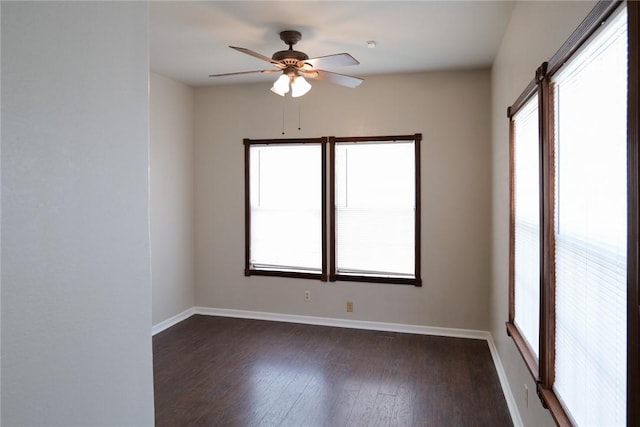 empty room with dark wood-style flooring, ceiling fan, and baseboards