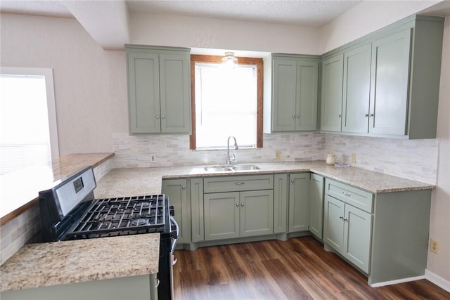 kitchen with dark wood-style floors, stainless steel range with gas cooktop, green cabinetry, and a sink