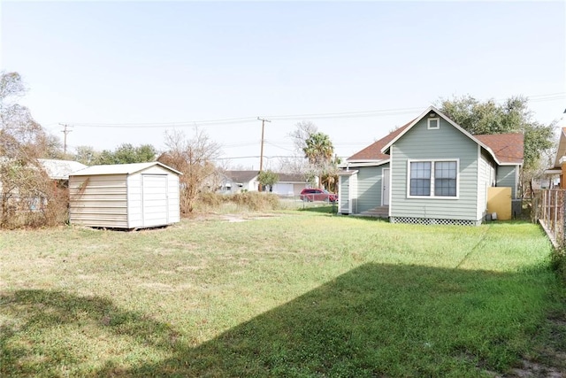 view of yard featuring an outbuilding, fence, and a storage unit