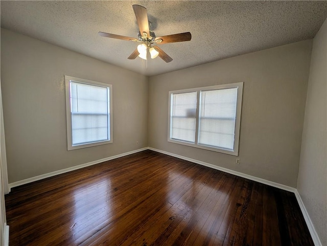 unfurnished room featuring dark wood-style floors, ceiling fan, a textured ceiling, and baseboards