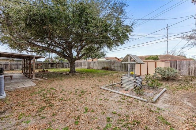 view of yard featuring a storage unit, a patio, an outbuilding, and a fenced backyard