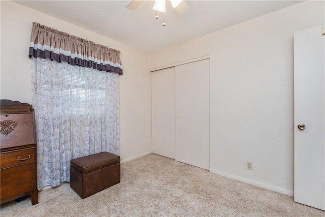 carpeted bedroom featuring a closet, baseboards, and a ceiling fan