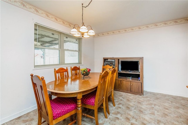 dining room with baseboards and a chandelier