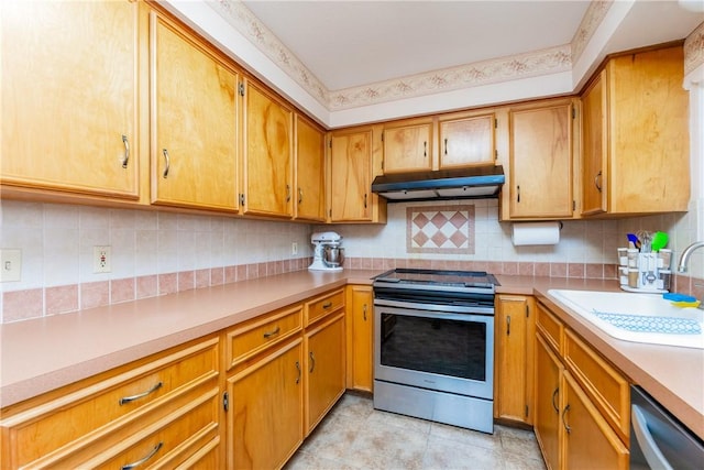 kitchen with under cabinet range hood, light countertops, appliances with stainless steel finishes, and a sink