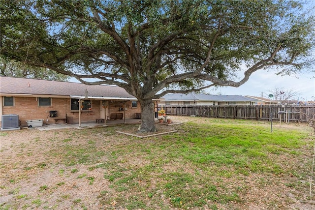 view of yard featuring a patio, central AC unit, and fence