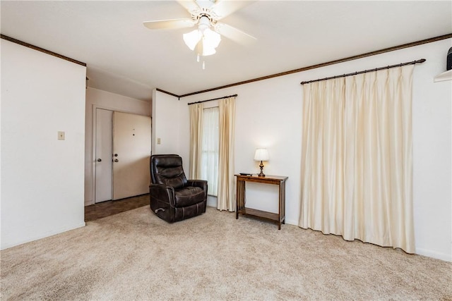 living area featuring light colored carpet, crown molding, and a ceiling fan