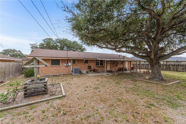 back of house with cooling unit, a patio, brick siding, and a fenced backyard