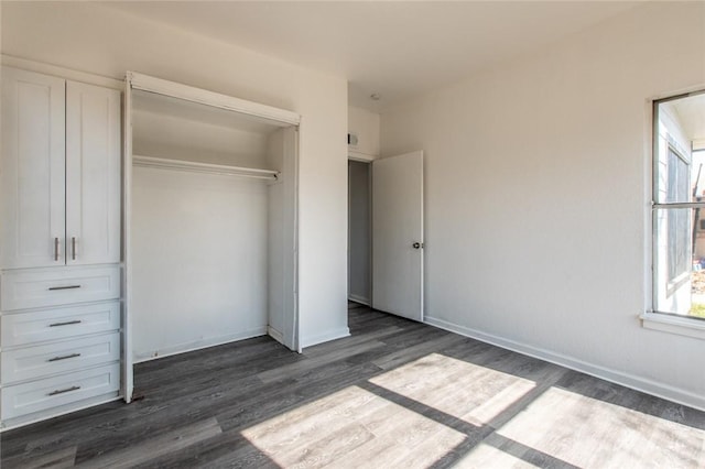 unfurnished bedroom with dark wood-type flooring and a closet