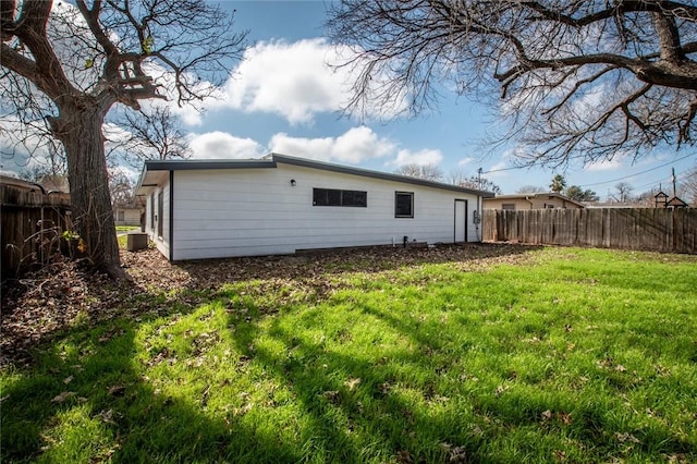 rear view of property featuring a yard and cooling unit