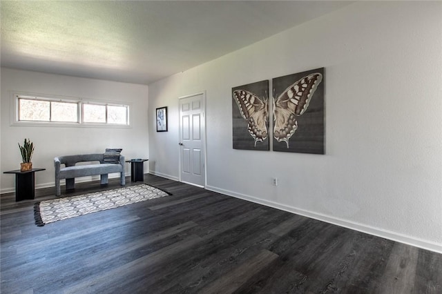 living area featuring a textured ceiling and dark hardwood / wood-style flooring