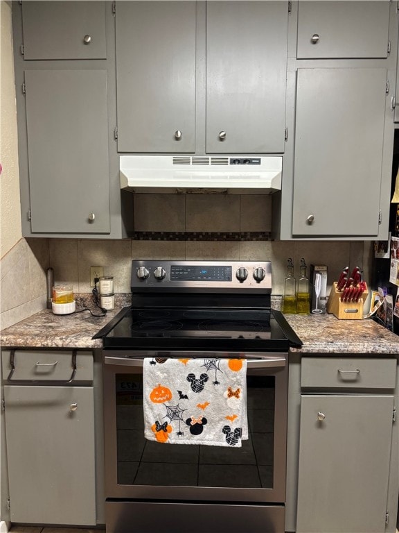 kitchen featuring gray cabinetry, decorative backsplash, stainless steel range with electric stovetop, and under cabinet range hood