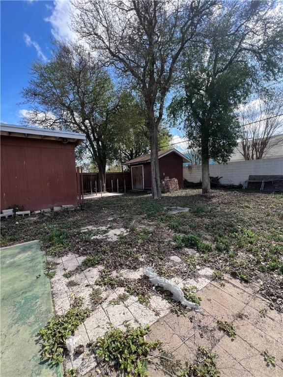 view of yard with fence and an outdoor structure