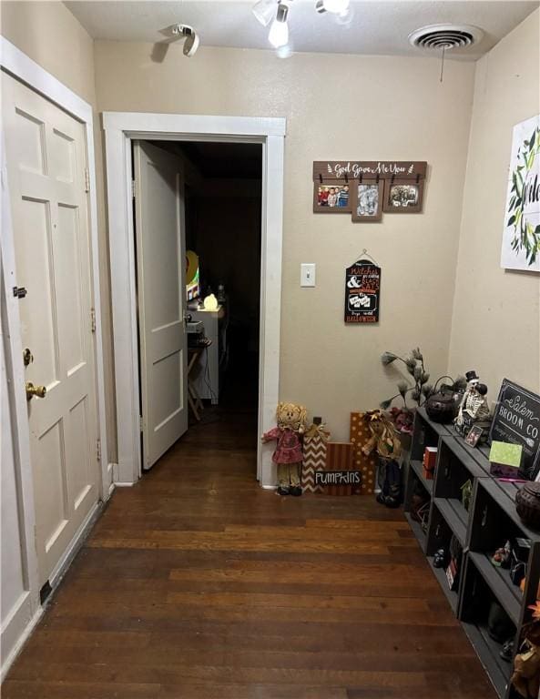 corridor featuring wood finished floors and visible vents