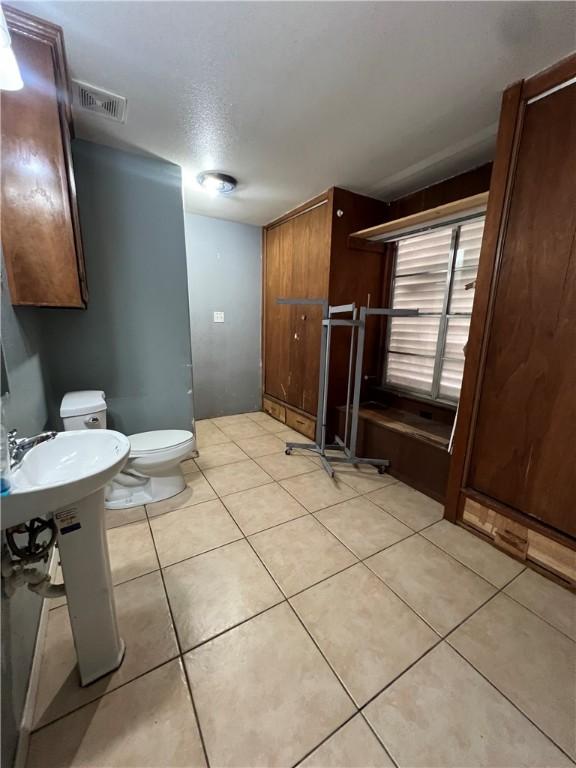 bathroom featuring toilet, tile patterned flooring, and visible vents