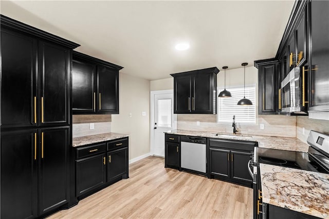 kitchen featuring appliances with stainless steel finishes, light wood-style flooring, and dark cabinets