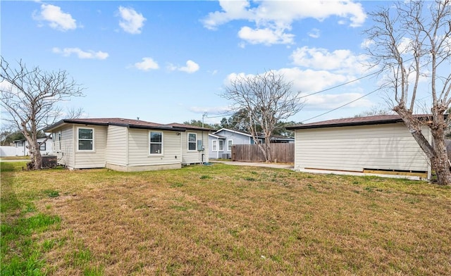 back of property with a yard and fence