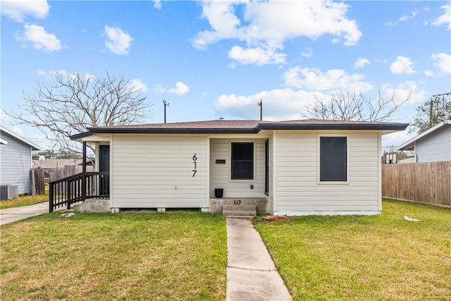 view of front of property featuring fence, a front lawn, and central AC unit