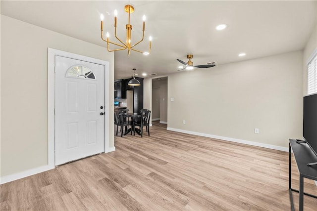 entrance foyer with light wood finished floors, ceiling fan with notable chandelier, baseboards, and recessed lighting