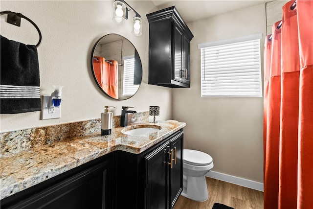 bathroom featuring toilet, vanity, wood finished floors, a shower with curtain, and baseboards