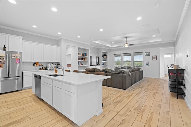 kitchen with sink, white cabinetry, a center island with sink, light hardwood / wood-style flooring, and stainless steel appliances