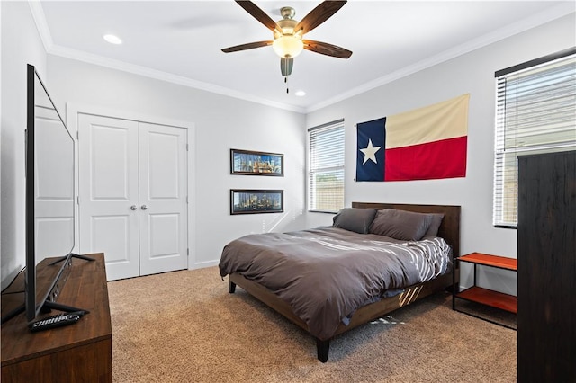 carpeted bedroom with ornamental molding, a closet, and ceiling fan