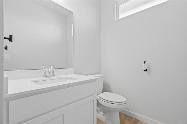 bathroom with vanity, toilet, and wood-type flooring