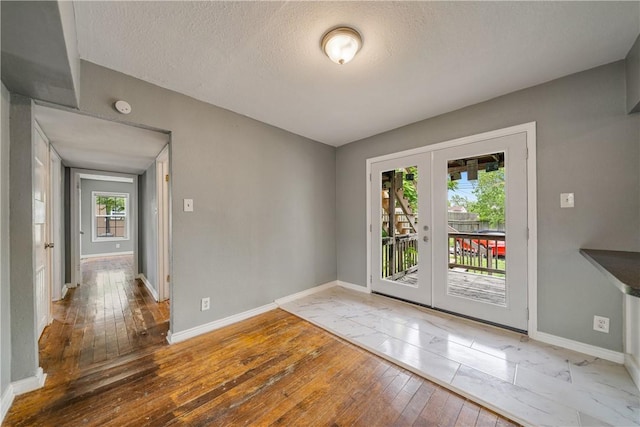 doorway featuring french doors, baseboards, and wood-type flooring