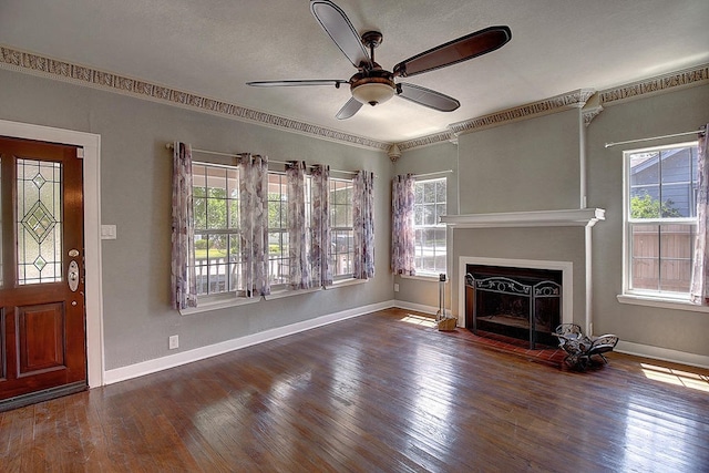 unfurnished living room featuring ceiling fan, crown molding, and dark hardwood / wood-style floors