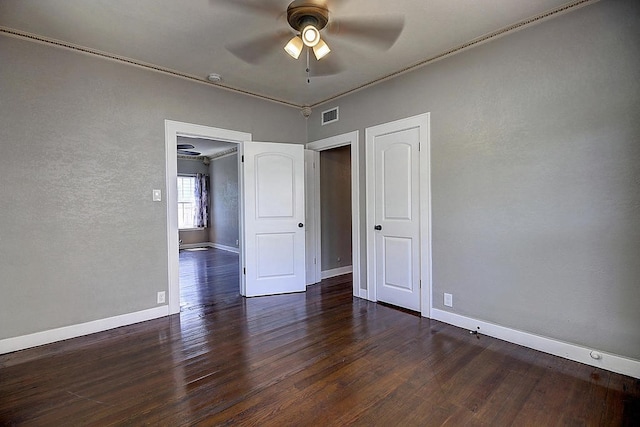 unfurnished bedroom with ceiling fan, dark hardwood / wood-style flooring, and ornamental molding