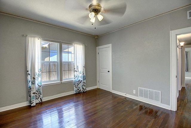 spare room featuring ceiling fan, dark hardwood / wood-style flooring, and crown molding