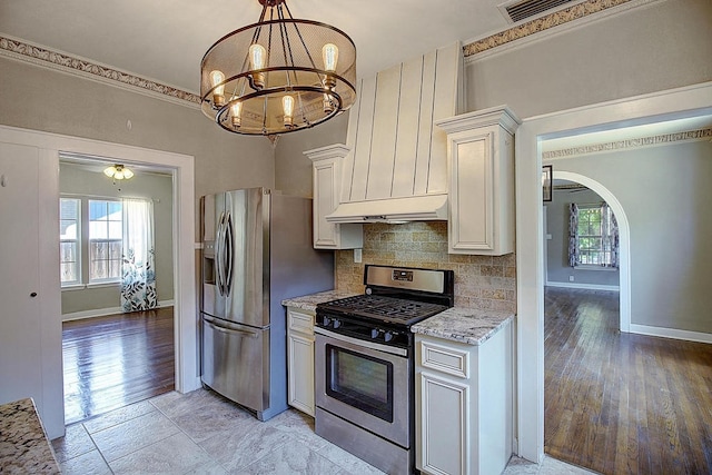 kitchen featuring range hood, a healthy amount of sunlight, light wood-type flooring, and appliances with stainless steel finishes