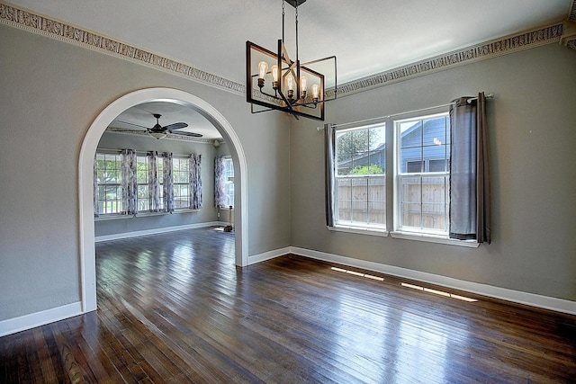 unfurnished room with ceiling fan with notable chandelier, dark hardwood / wood-style flooring, a wealth of natural light, and ornamental molding